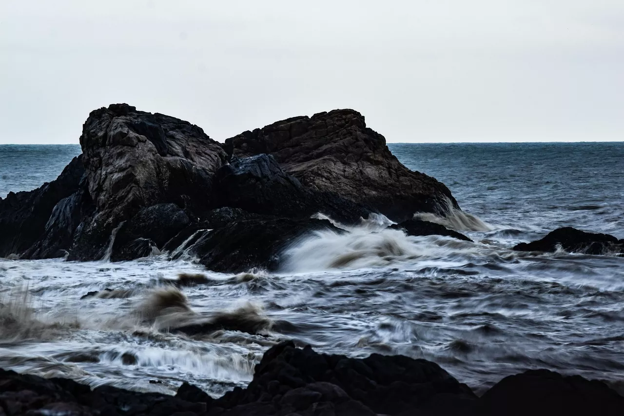 Powerful ocean wave crashing against rocks